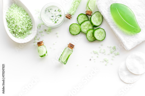 Fresh organic cosmetics with cucumber. Cream, lotion, spa salt on white background top view copyspace
