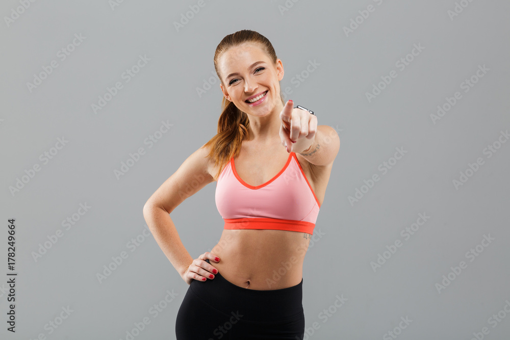 Happy young sports woman pointing to you. Happy young sports woman pointing to you.