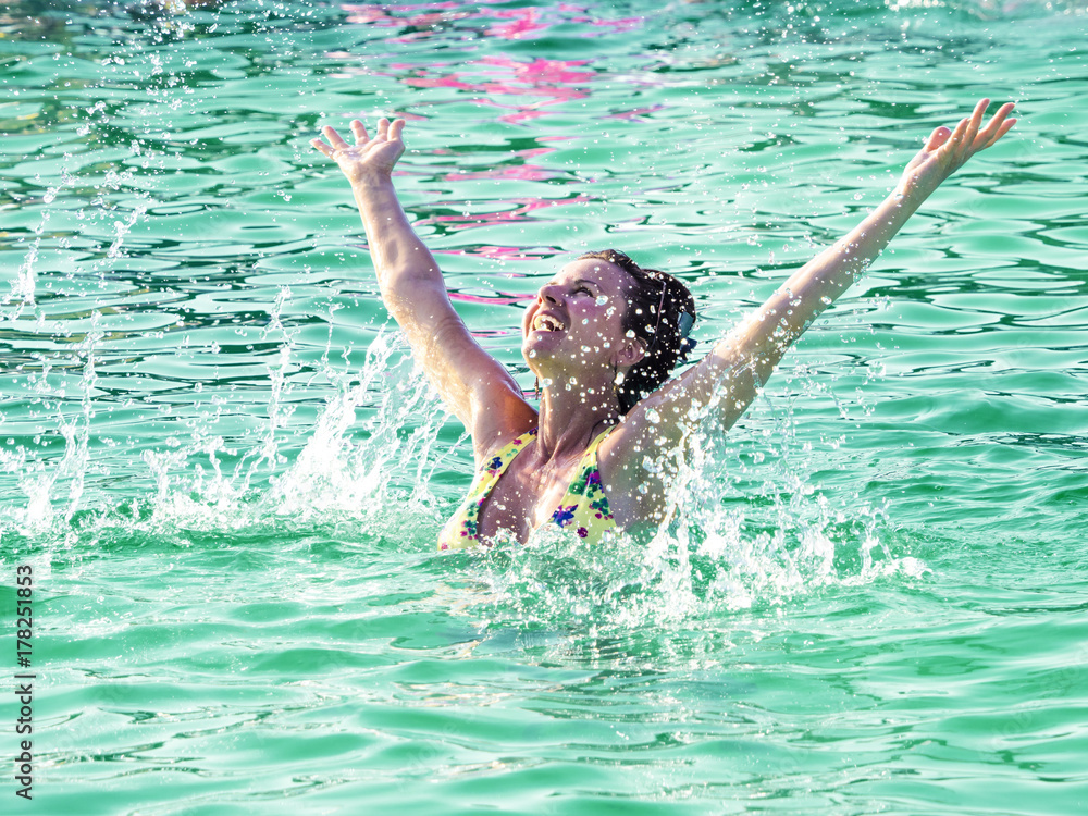 The girl is making a jump from the pool