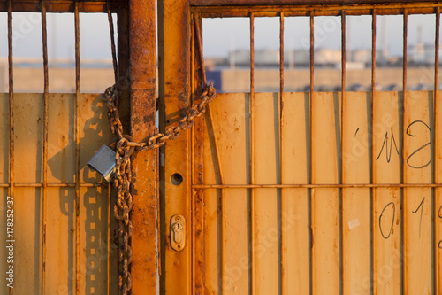 Puerta de verja con candado oxidado en salitre photo