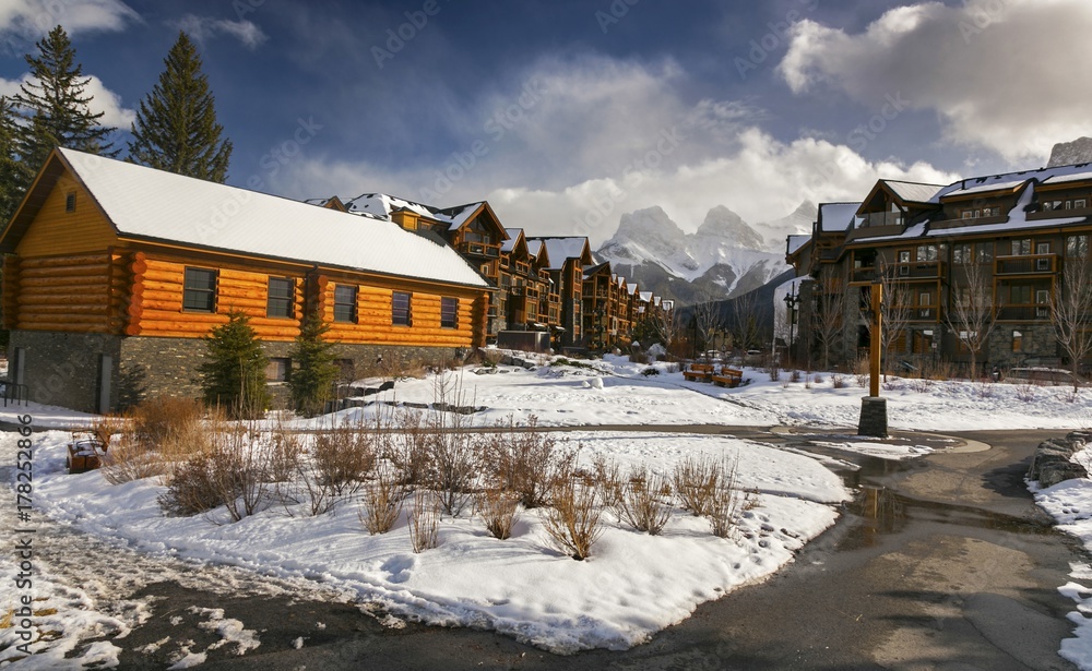 Spring Creek Alpine Village Landscape in Canmore, Alberta and distant snowy Three Sisters Rocky Mountain Tops near Banff National Park Canada