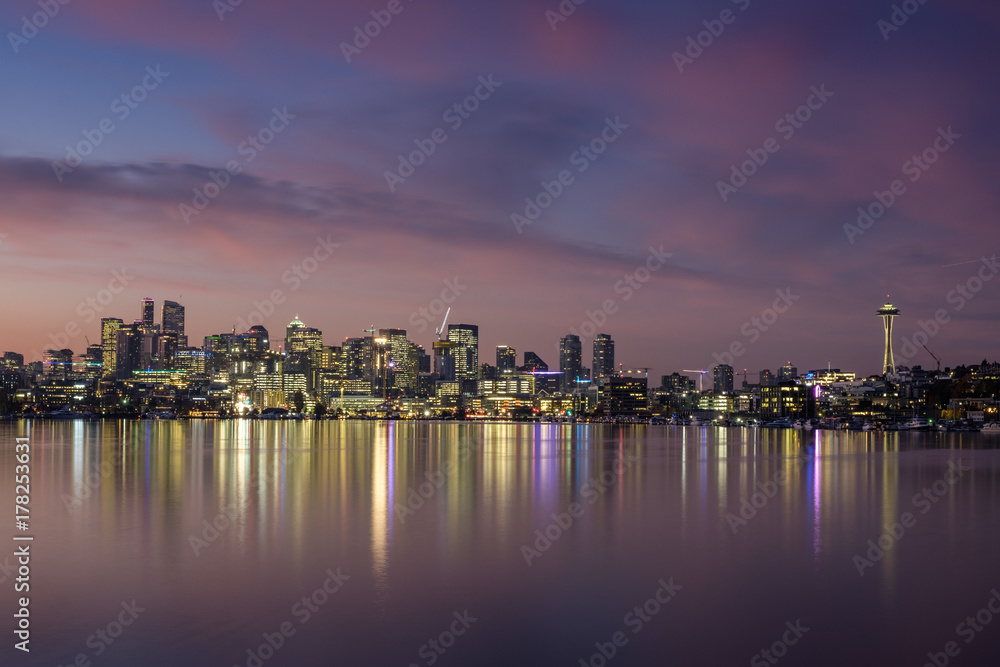 Dawn breaks over the Seattle skyline with reflections on the water