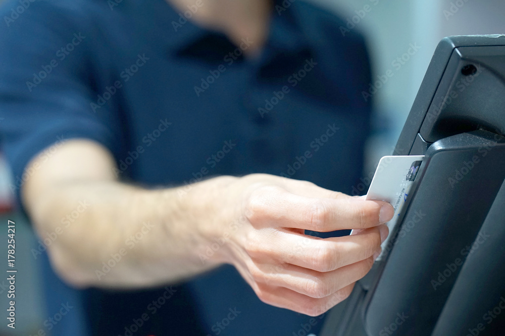 Credit card payment terminal in store. Seller draws up credit card purchases. close-up of a seller with a credit card