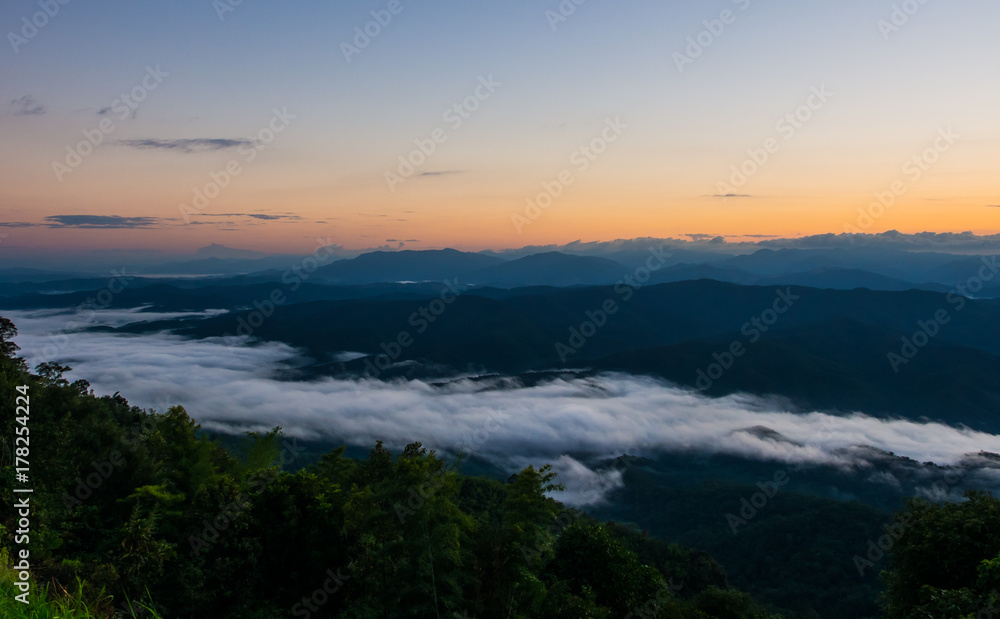 The little myst of fog along the long range of mountain behind the green forest. The travelers cloud visit and take some fresh breath of oxygen at this place, Doi Samer Dao, Nan, Thailand The little myst of fog along the long range of mountain behind the green forest. The travelers cloud visit and take some fresh breath of oxygen at this place, Doi Samer Dao, Nan, Thailand