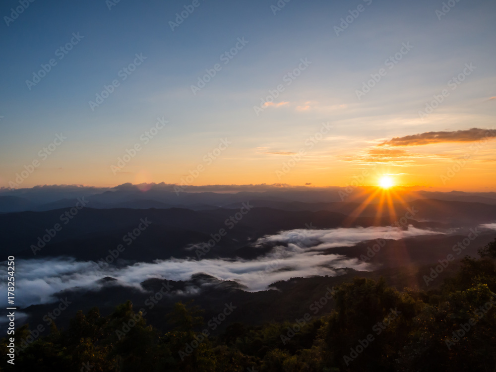 Sun rises above the long range of hills and white fog at Doi Samer Dao, one of the best location to see the fog in Nan, Thailand Sun rises above the long range of hills and white fog at Doi Samer Dao, one of the best location to see the fog in Nan, Thailand