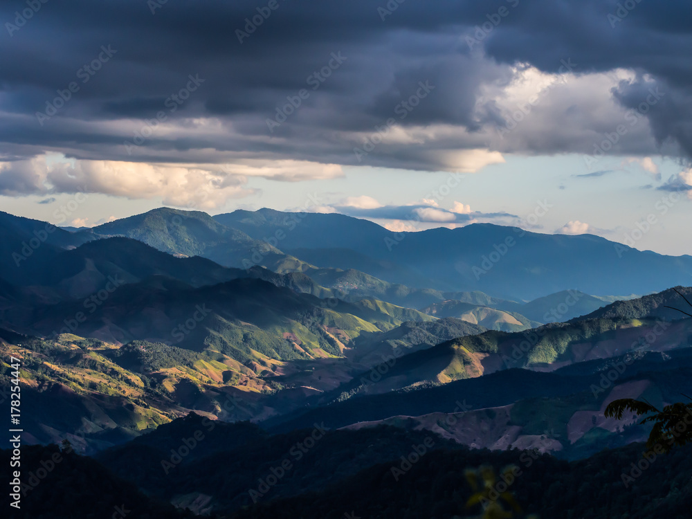 The great moment of nature where the sunlight is shine toward the mountain valley while trekking to the top of Doi Phu Wae at Nan, Thailand. The light is so bright comparing to the dark cloudy sky