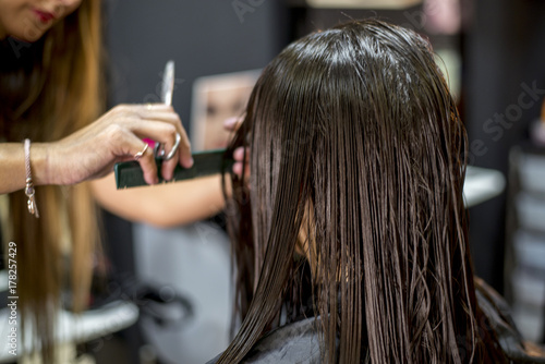 A Hairdresser in action cutting long hair