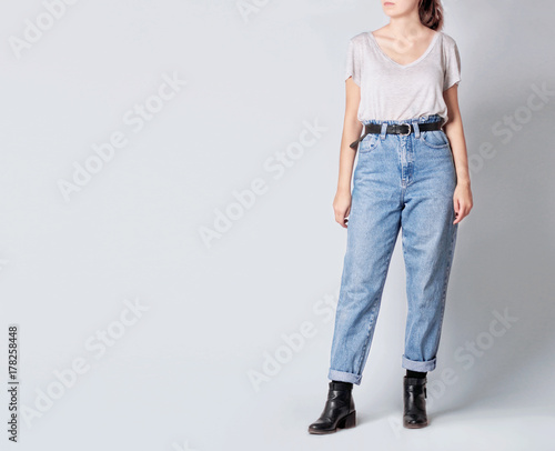 Woman Wearing Casual Outfit With White T Shirt Blue Vintage High Waisted Mom Jeans With Black Faux Leather Ankle Boots And Black Belt Isolated On Grey Background Copy Space Stock Photo Adobe Stock Woman Wearing Casual Outfit With White T Shirt Blue Vintage High Waisted Mom Jeans With Black Faux Leather Ankle Boots And Black Belt Isolated On Grey Background Copy Space Stock Photo Adobe Stock