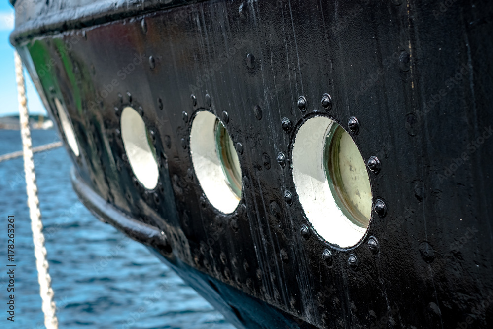 Fototapeta premium Close view of rounded porthole windows in the green side of the ship.
