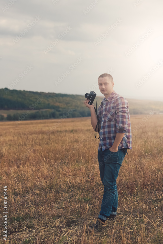 Attractive male photographer outdoors at sunset