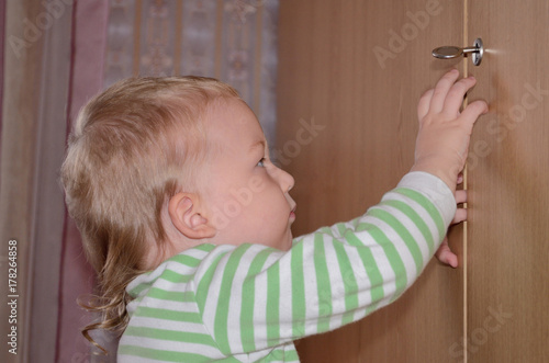 little child try to open the door at home