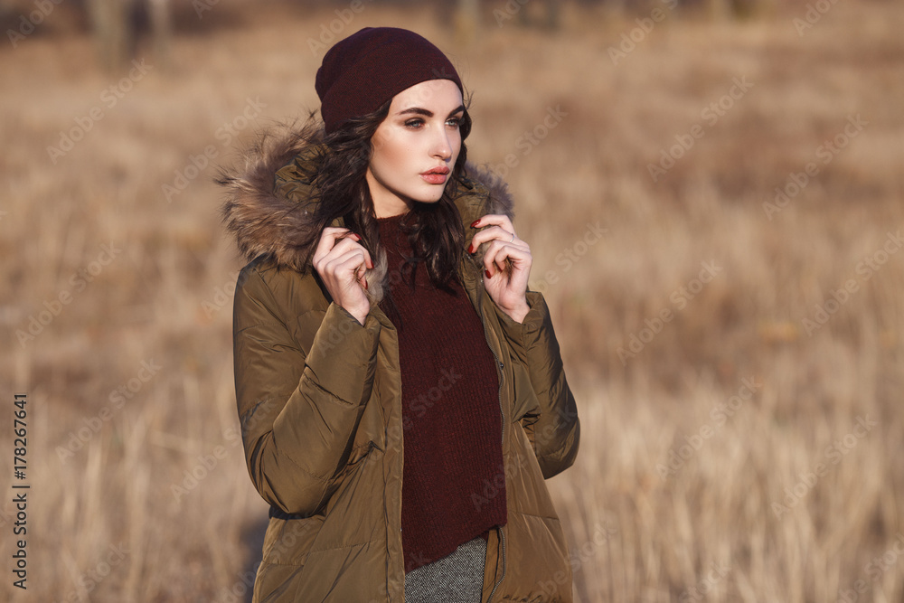 Beautiful Young Girl in her Winter Warm Fashion Clothing. Down jacket and warm hat. Casual style. Beautiful Young Girl in her Winter Warm Fashion Clothing. Down jacket and warm hat. Casual style.