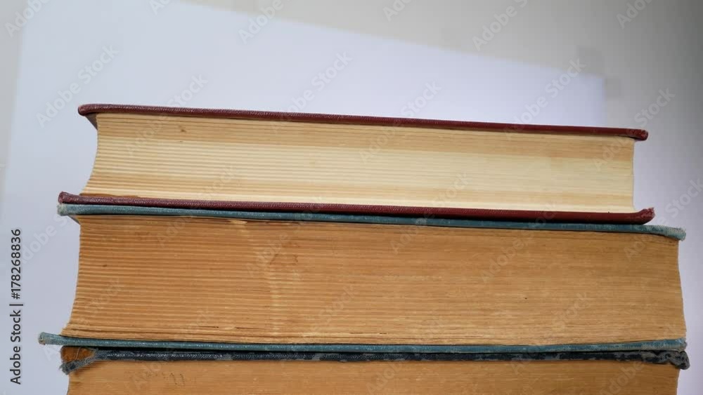 Student's Hands Take Old Books One On Another On The Table. Ancient Books On Bookshelf Student's Hands Take Old Books One On Another On The Table. Ancient Books On Bookshelf