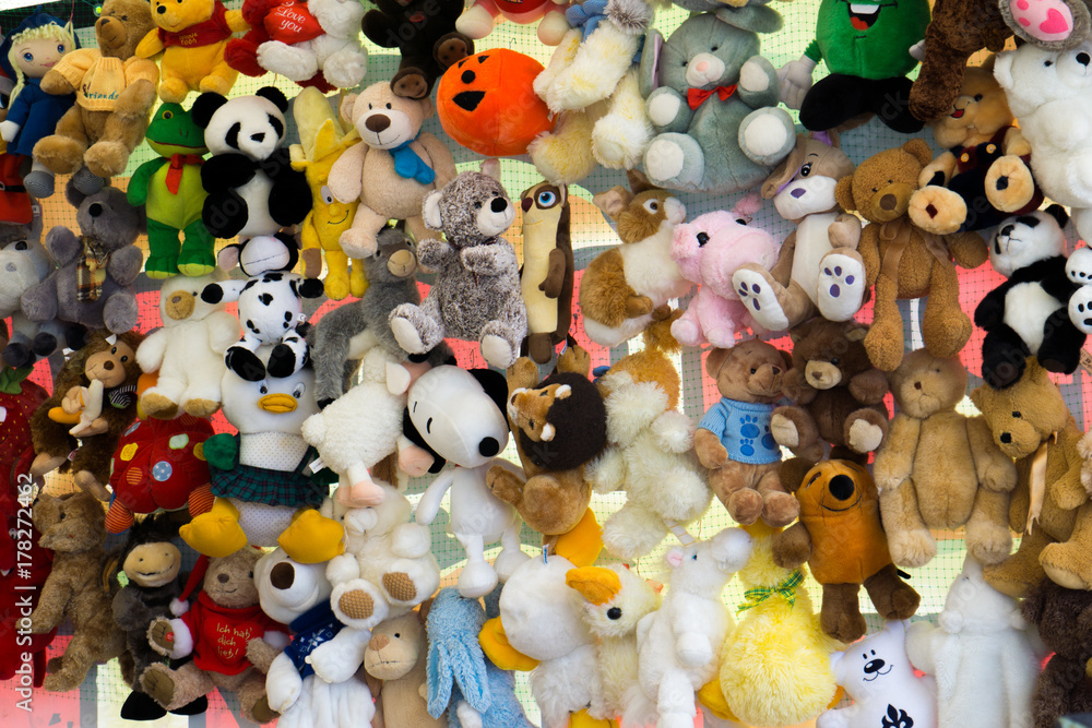 Children's colorful soft toys hanging on strings at a market