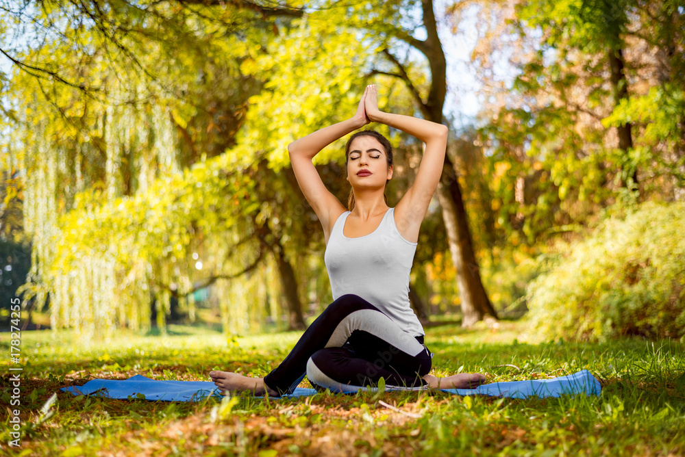 Young beautiful woman practicing yoga in the park. Young beautiful woman practicing yoga in the park.