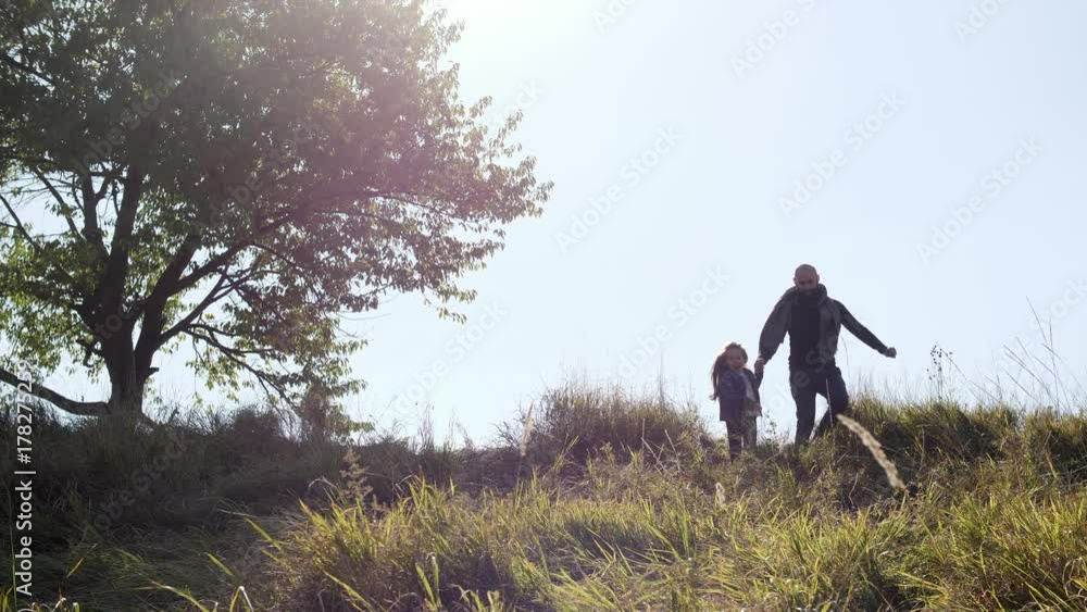 Father with his daughter running from the hill. Father with his daughter running from the hill.
