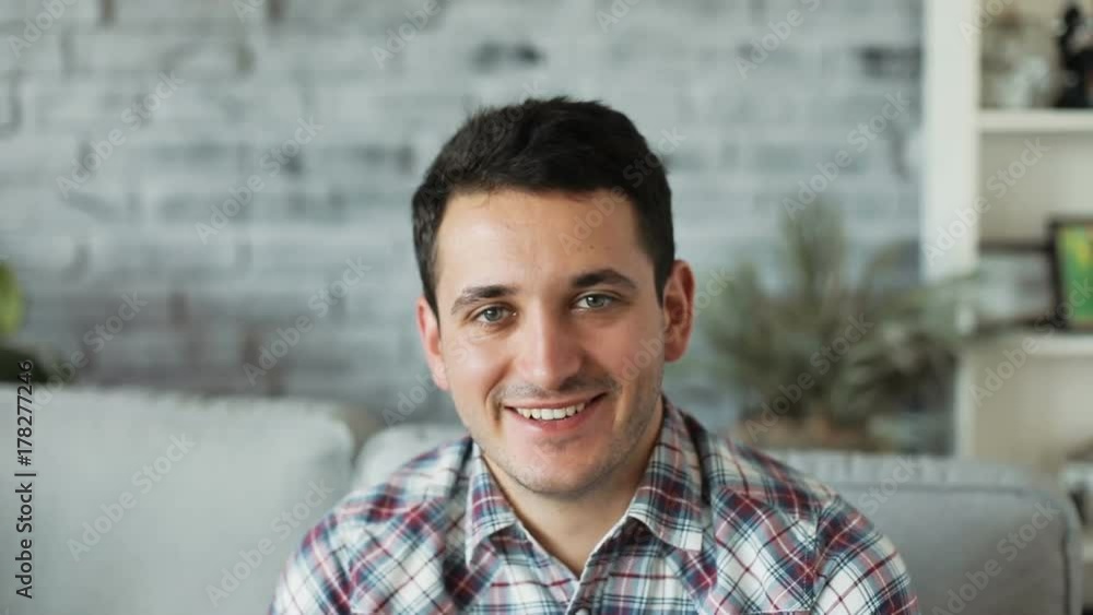 portrait of attractive young man smiling at camera at home handsome joy leisure looking at camera modern positive satisfied male face guy close up Shot on RED EPIC camera. Slow Motion Shot. portrait of attractive young man smiling at camera at home handsome joy leisure looking at camera modern positive satisfied male face guy close up Shot on RED EPIC camera. Slow Motion Shot.