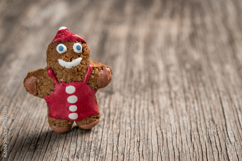 Obraz premium Decorated gingerman cookie on rustic wooden background