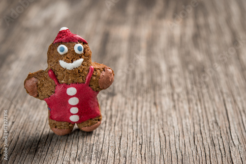 Decorated gingerman cookie on rustic wooden background