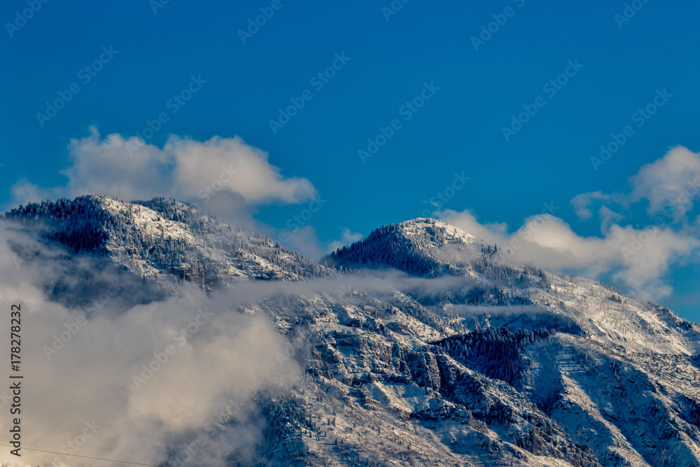 Mountain peaks above the clouds with snow