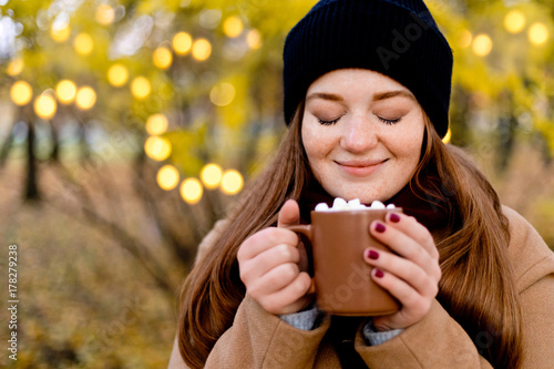 Girl drinks cocoa with marshmallow. Cozy winter morning, New Year's and Christmas holidays