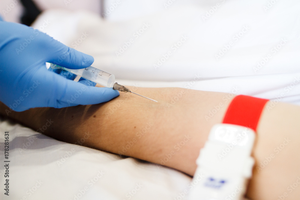 A nurse prepares to inject injection needles into the patient. A nurse prepares to inject injection needles into the patient.