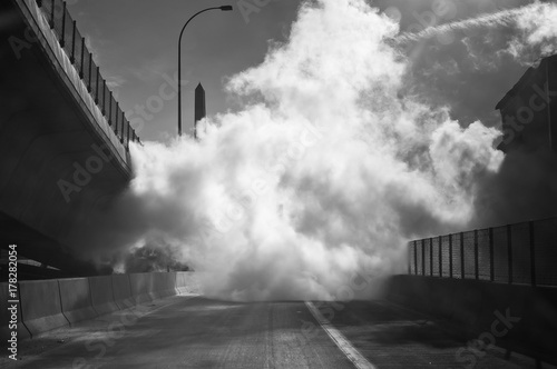 Thick cloud of steam sits on road. photo