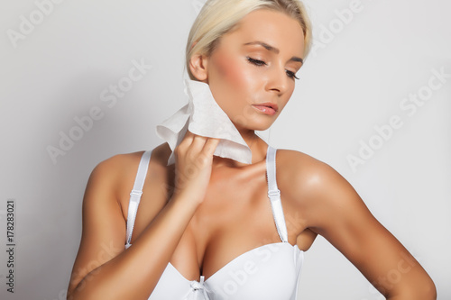 Woman clean neck with wet wipes