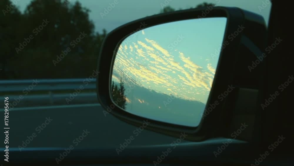Highway road travel seen from side mirror with a sunrise sunset Highway road travel seen from side mirror with a sunrise sunset