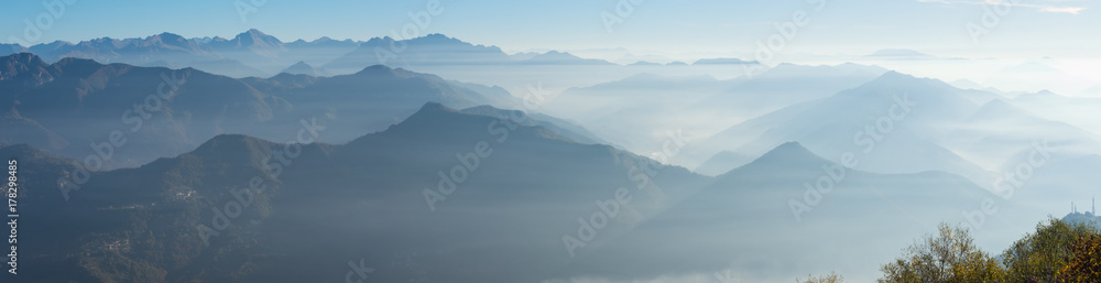 Morning landscape on hills and mountains with humidity in the air and pollution. Panorama from Linzone Mountain, Bergamo, Italy Morning landscape on hills and mountains with humidity in the air and pollution. Panorama from Linzone Mountain, Bergamo, Italy