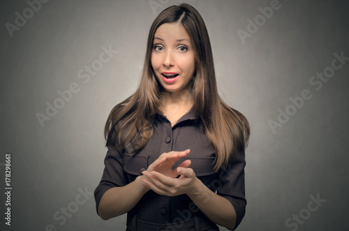 Astonished young happy smiling girl in dress clapping enthusiastically isolated.