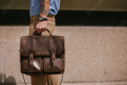 Young man walking downtown with briefcase