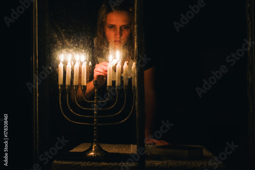 lighting candle in a menorah for Chanukah photo