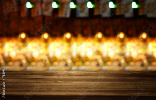 Image of wooden table in front of abstract blurred restaurant lights background