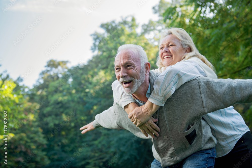 Happy senior couple smiling outdoors in nature  - obrazy, fototapety, plakaty 