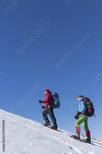 Two men climb in the winter in the mountains.