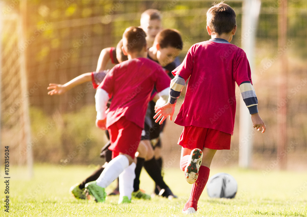 Fototapeta premium Kids soccer football - children players match on soccer field