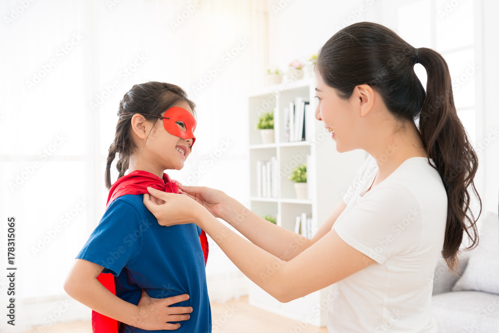 Obraz premium happy attractive mother helping cheerful daughter