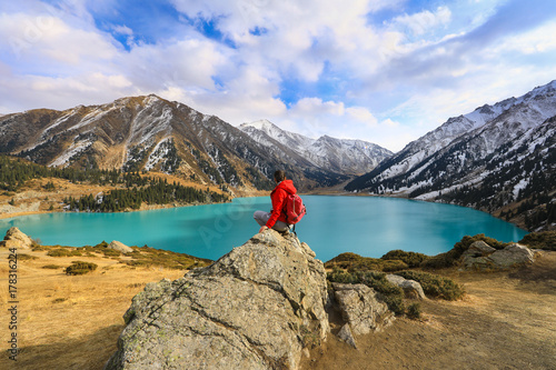 girl sitting on a mountain, mountain lake,Big Almaty Lake, Kazakhstan, Almaty