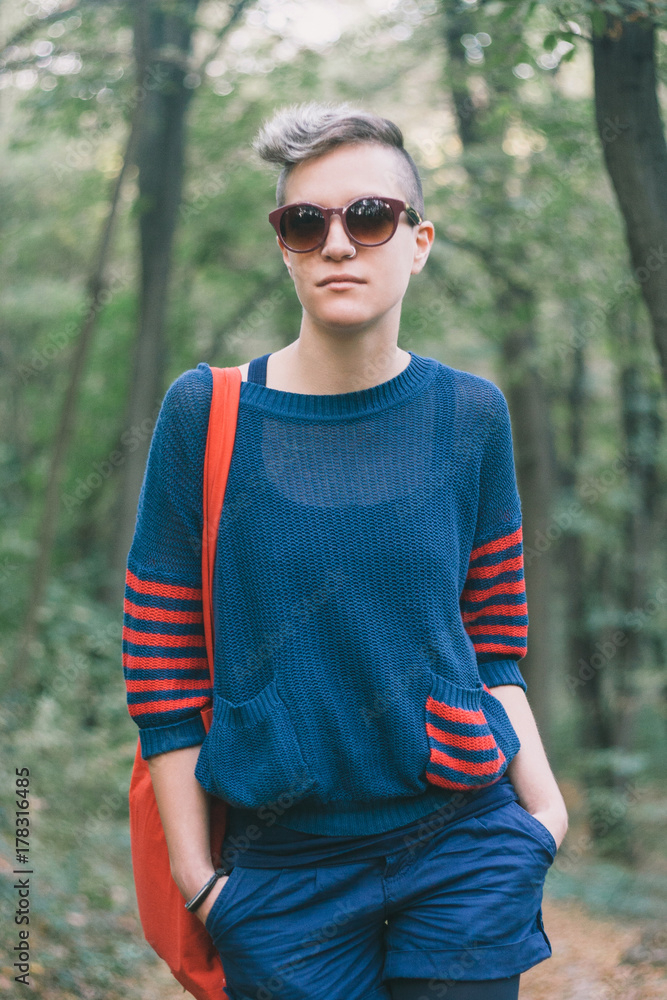 Portrait of a young girl with sunglasses, standing in the forest Portrait of a young girl with sunglasses, standing in the forest