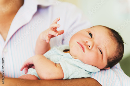 Adorable one day old baby holding by a parent