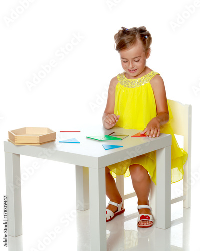 A little girl is studying Montessori stuff.