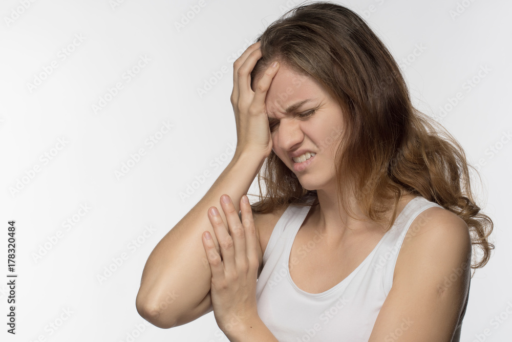 Young girl experiencing headache or depression and mourned over white background Young girl experiencing headache or depression and mourned over white background