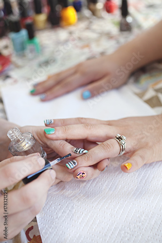 close up of a lady's hand receiving a manicure / nail art, clear coat photo