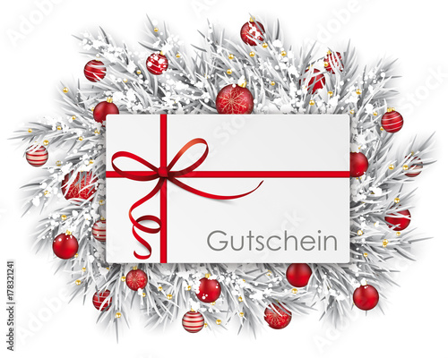 Weihnachtsgutschein auf den eingeschneiten Tannenzweigen mit Weihnachtskugeln