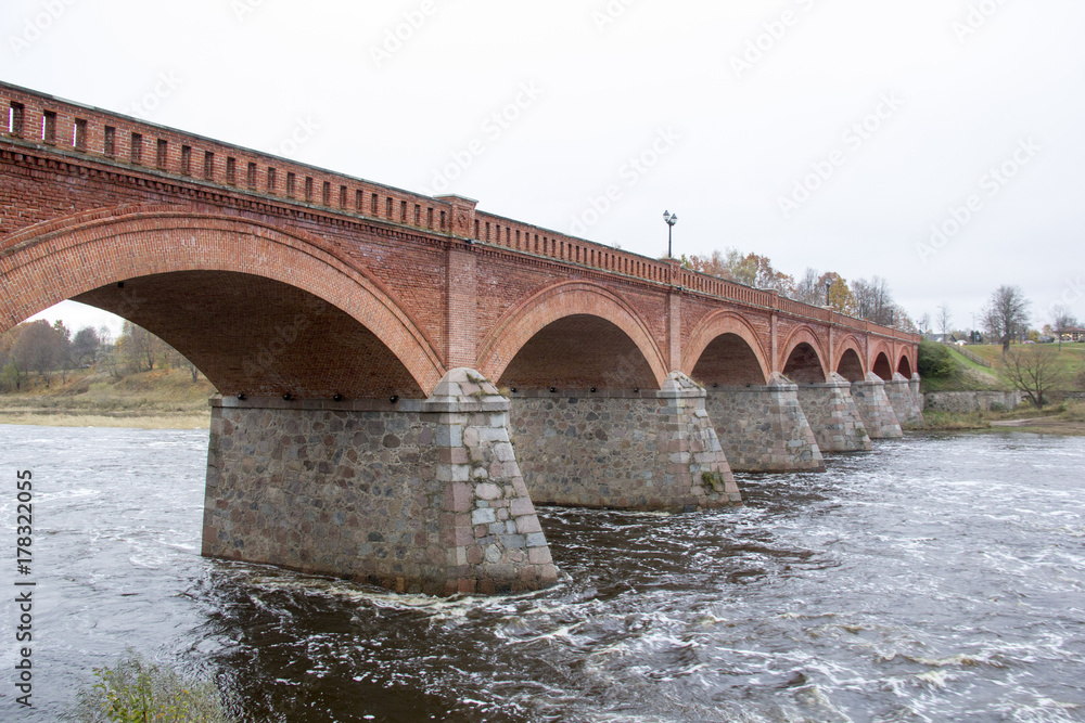 old Brick bridge across the River Venta in the city of Kuldiga Latvia