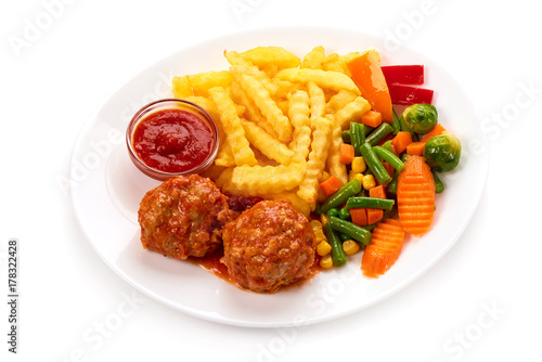 Meatballs in tomato sauce with potatoes fries and vegetables, isolated on white background