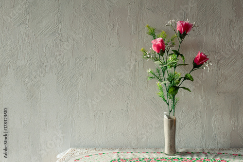 Odd Plastic Flower Decoration in Front of  Roughcast Wall