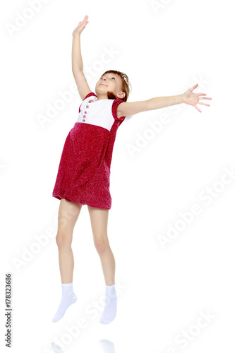 Little girl jump with her hands up.