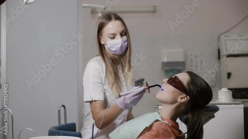 Dentist uses dental polymerization lamp photo